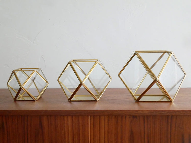 Horn Please MADEの金色真鍮フレームを持つ三角形ガラスケース内のフィギュア