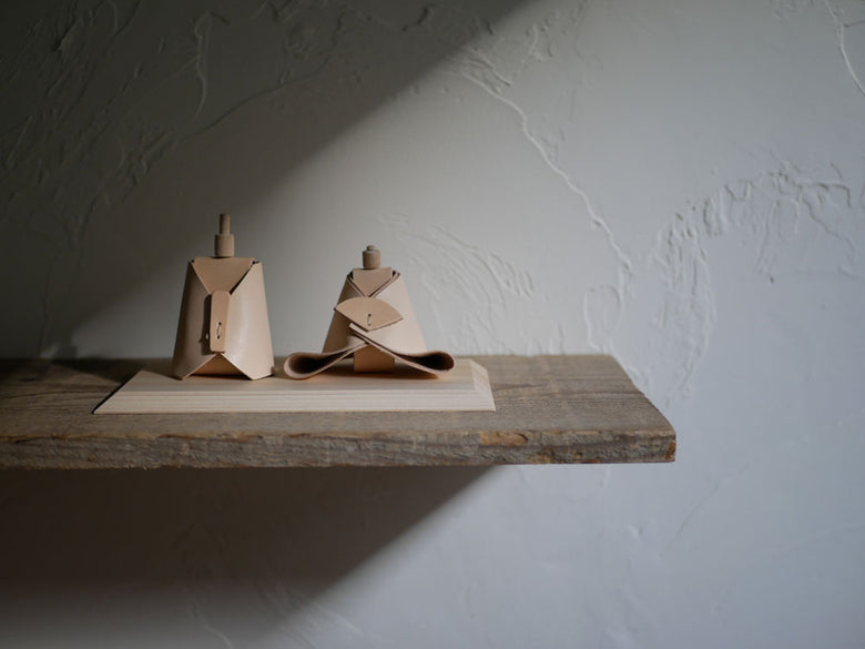 Comore Sunブランドのヌメ革製お内裏様とお雛様がヒノキの台座に並べられたお雛人形
