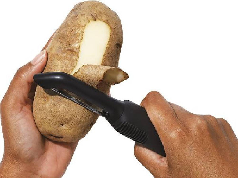 OXO/オクソーのGood Gripsタテ型ピーラーとポテトがキッチン台で使用されている様子