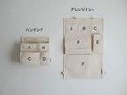 ホーンプリーズ MADEのキャンバスハンギングアレンジメントポケット。縦40cm×横7cm×高さ60cm、多数のサイズ別ポケットが特徴のインド製製品