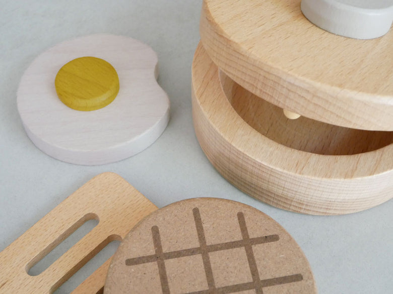 dou?のままごとがっき pop pan、直径9.3cmの木製フライパンやたまご、ハンバーグ、フライ返しがセットになった10ヶ月以上対象の安全な幼児用模擬調理玩具