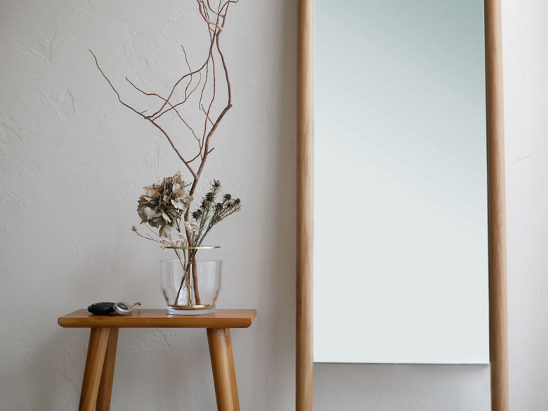 フリッツ・ハンセンのIKEBANA、木製の花瓶に生けられた観葉植物と木材の背景が特徴のアレンジメント