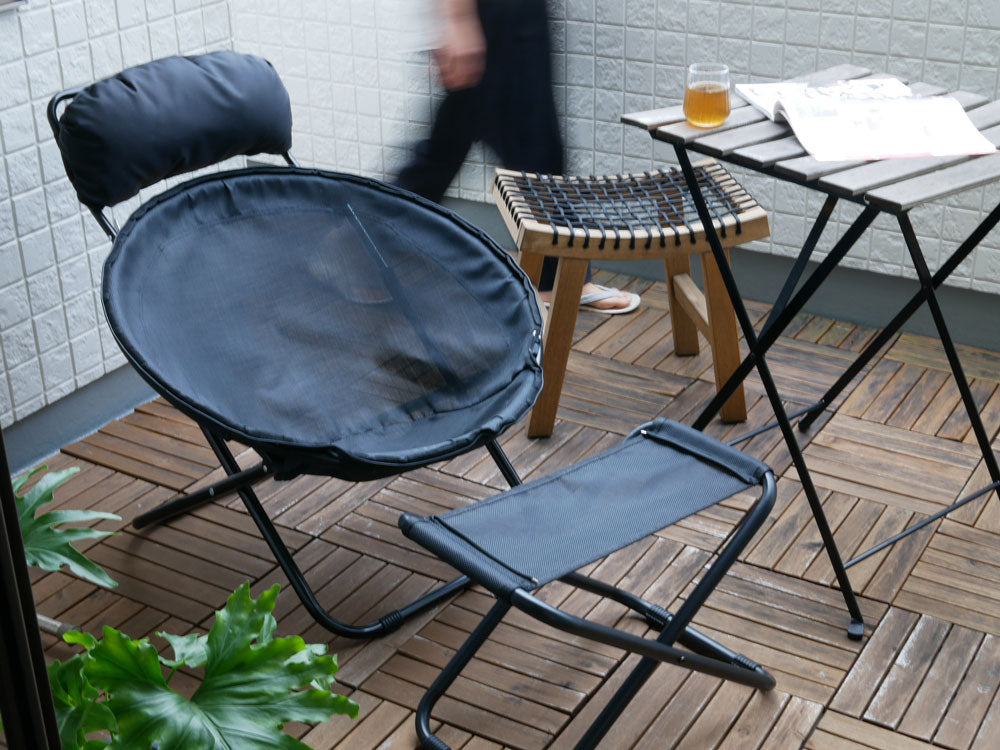 灰色の折りたたみ可能なアウトドアチェアと木製コーヒーテーブルが配置された屋外家具セット