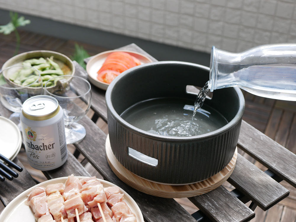 サリュー製美濃焼炭焼き水コンロと付属のトングおよび焼網がキッチンテーブルに整然と配置されている様子