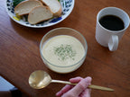 自動調理ポットに盛られたリークスープと食器類が配置されたキッチンの風景