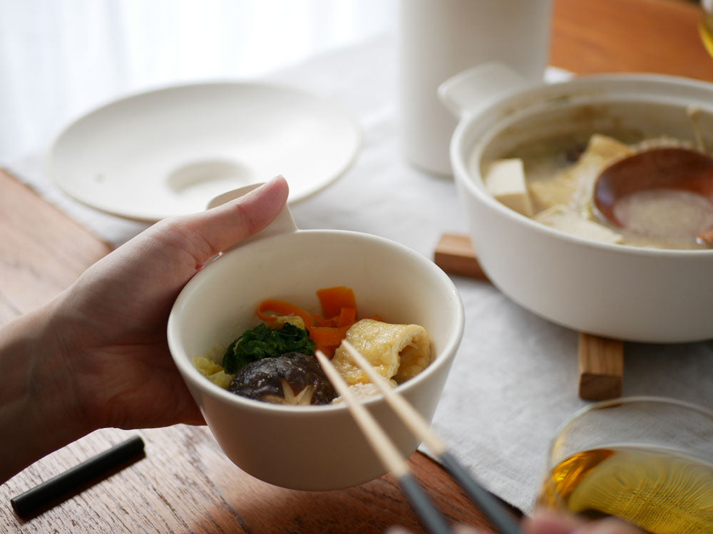 サラサデザインの1年中使えるマルチ土鍋ととんすい、ツールスタンドが並び、野菜入りスープとともに食卓にセッティングされた様子