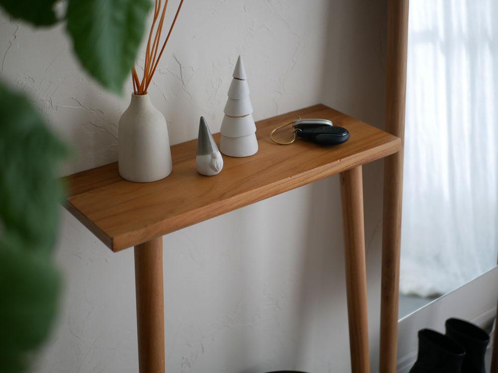 木製のエンドテーブルの上に置かれた九谷焼のサンタクロースフィギュアと花瓶、観葉植物