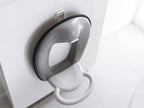 白色のタワーシリーズフィルムフックトイレ用品収納フックが銀色のトイレ便座に取り付けられている様子