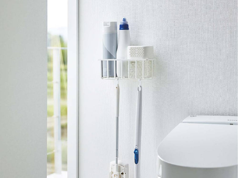 【タワー】ウォールトイレ用品収納ラックが浴室の壁に設置され、歯ブラシやペーパータオル、タオルなどの家庭用品を整然と収納している様子
