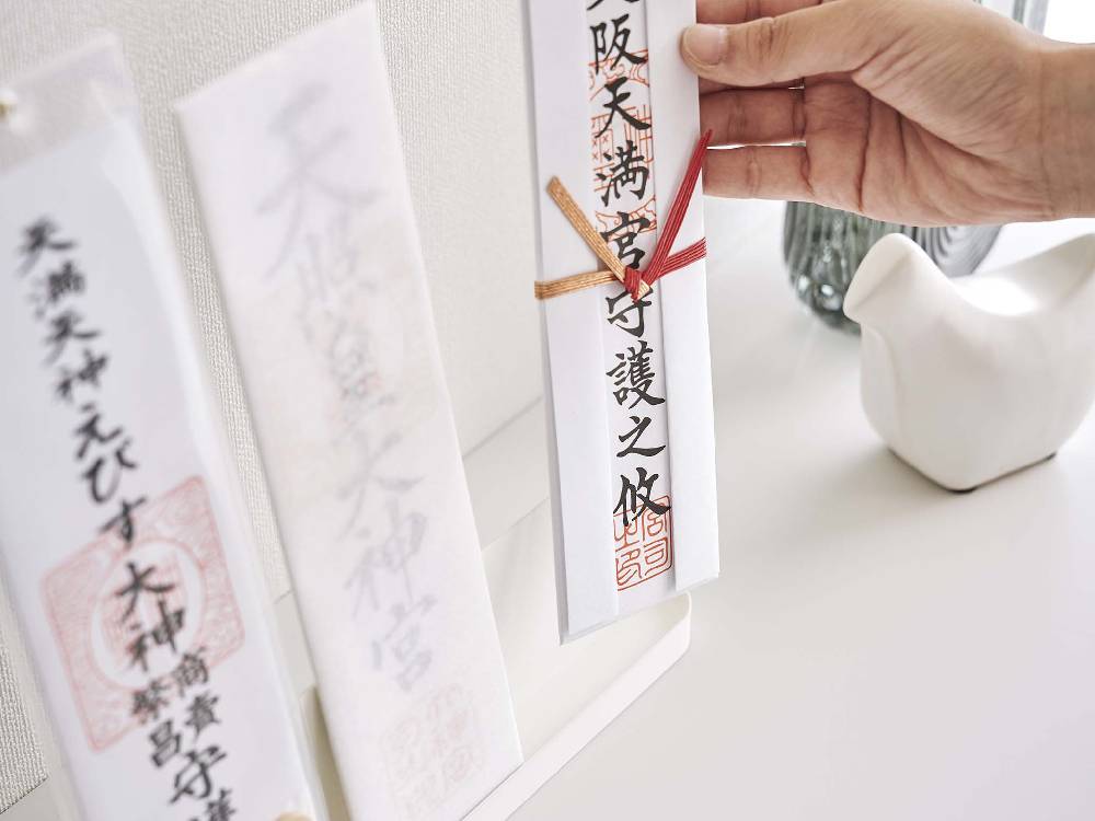 スチール製のスマート神札スタンドに手書きの神札が飾られている写真