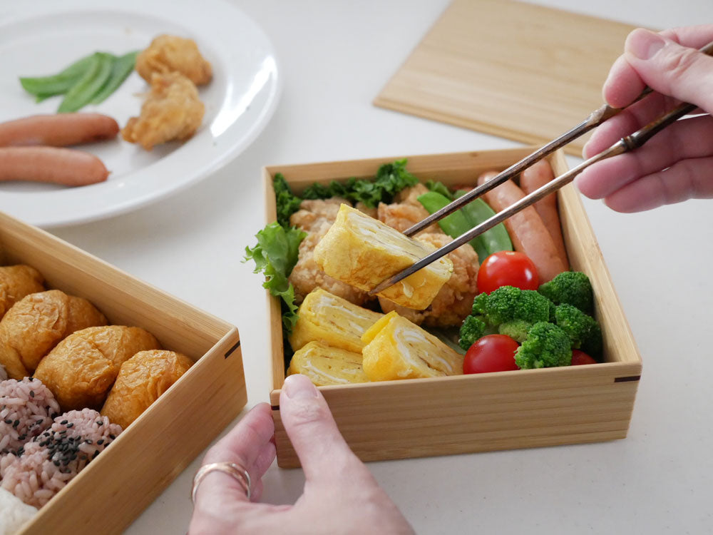 色とりどりの野菜や果物が美しく盛り付けられた竹製の二段重箱