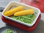 récolteの丸洗い可能なコンパクトホットプレート用セラミックスチーム深鍋セットと、野菜やキッチン用品がキッチンテーブルに整然と配置されている様子