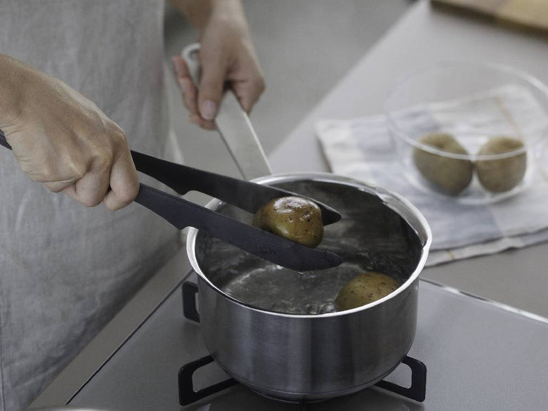 マーナのきほんトングがキッチンで野菜をつかんで調理している様子