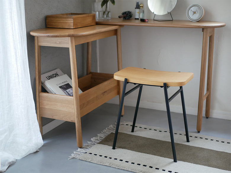 NOWHERE LIKE HOMEのKAPELLスツール。繊細なカーブが美しい木製デザインで、オーク、ウォルナット、ブラックの仕上げが選択可能。インテリアに調和するスタイリッシュな家具。