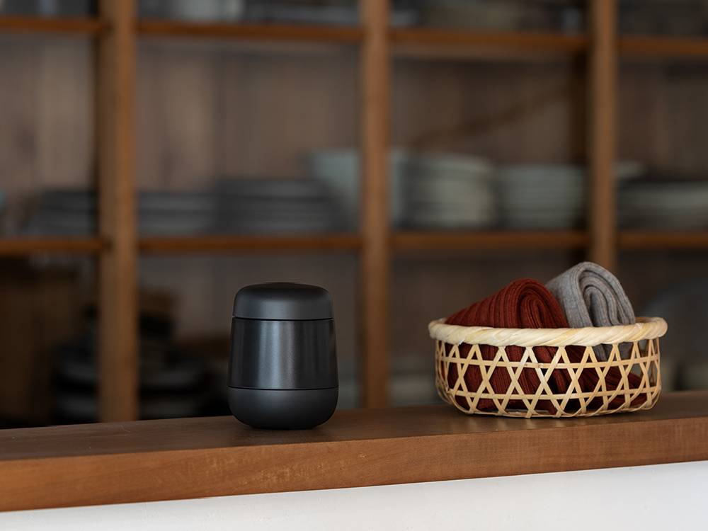 プラスマイナスゼロ毛玉クリーナーの円筒形本体。ABS樹脂とプラスチックで作られ、蓋が付いており、LEDインジケーターとスピーカーが搭載されています。