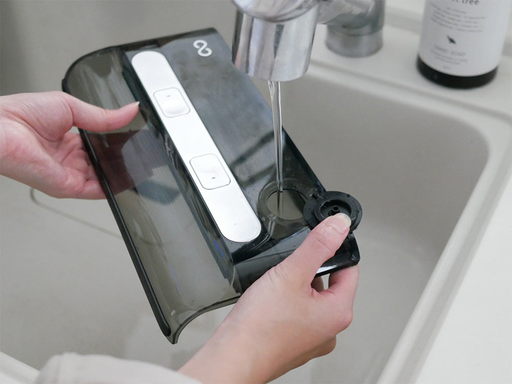 ミンドー AquaX 掃除機本体と充電スタンド、ロールブラシ、フィルターなどの付属品が並んだシルバーの家庭用電子機器