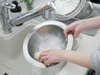 キッチンシンクに置かれたアーネストのとにかく洗いやすいステンレス卓上鍋とのせるだけ蒸し器のセット