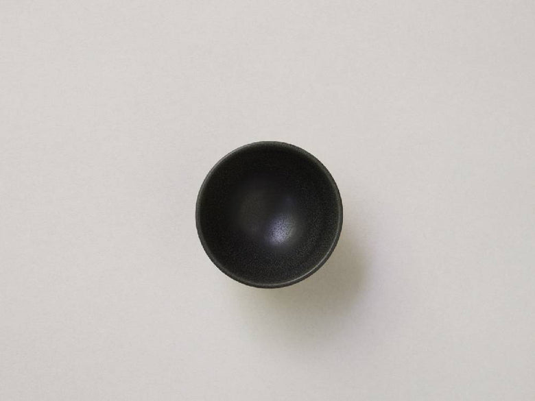 シルバーのボタンが付いた白黒陶器の急須と小茶碗がバランスよく配置された静物写真