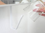 プラスチック、ガラス、銀の調理器具が収納された洗面戸棚下ホルダー